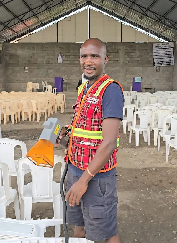 An engraver marking stacked plastic chairs on site